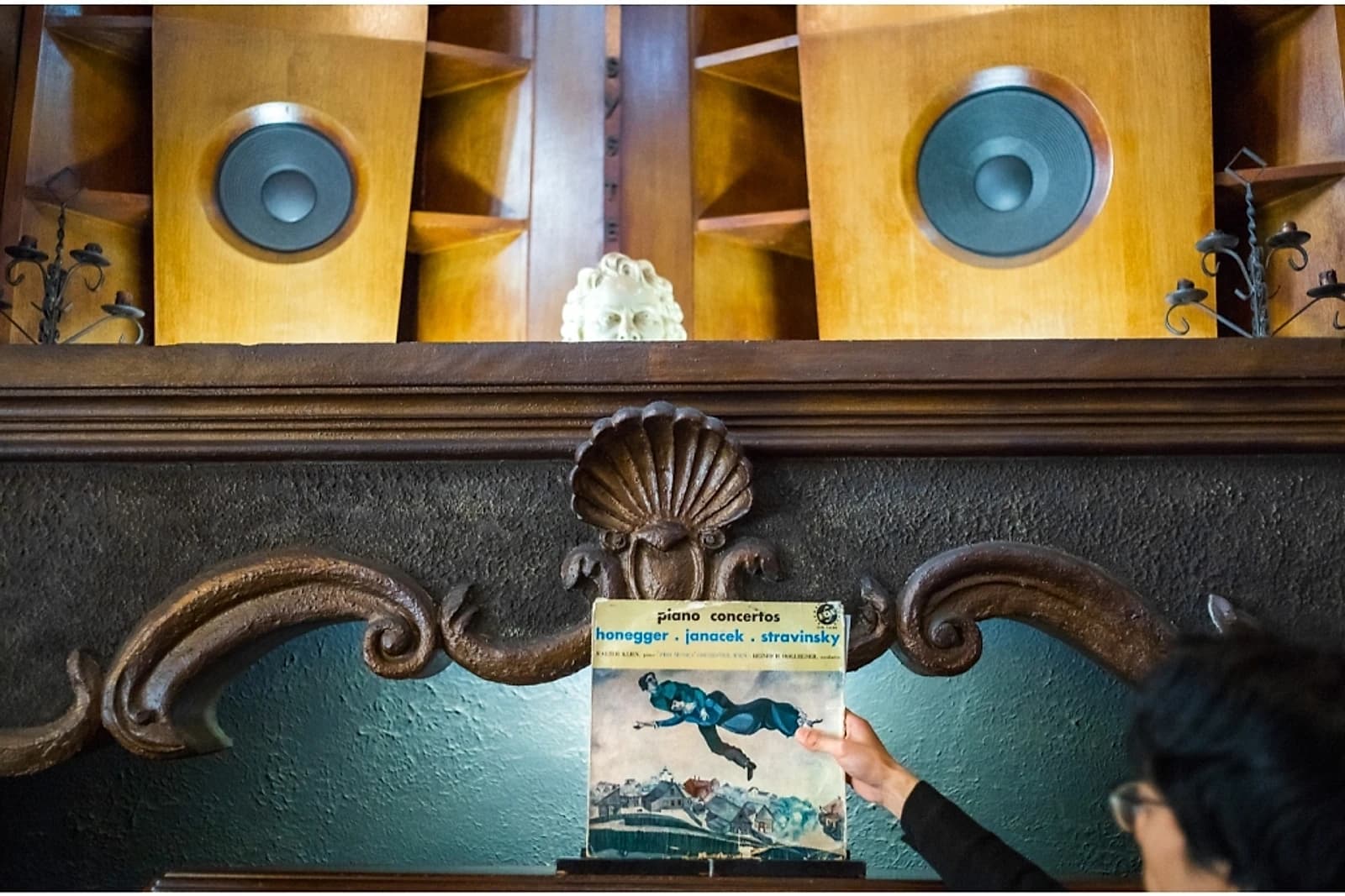 A classical record sleeve held up against a wall of vintage speakers inside one of Tokyo's ongaku kissa.