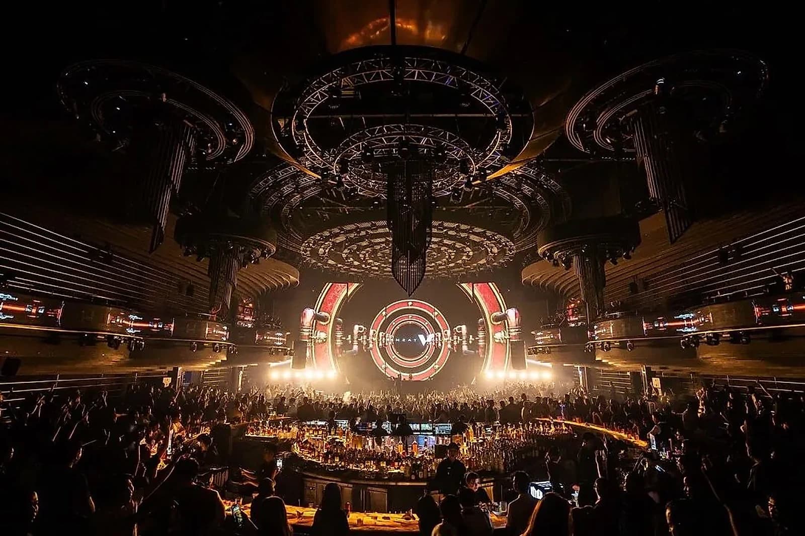 The horseshoe bar and stage that anchor The H Club's main floor, seen from the upper tier.