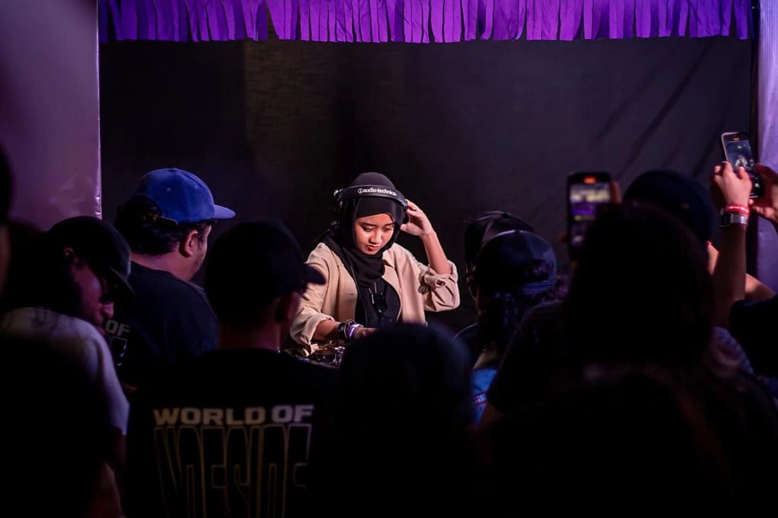 Naiko adjusts her headphones mid-set at Atas Angin Festival. She taught herself to DJ from YouTube tutorials at 15 and played her first live gig four years later.