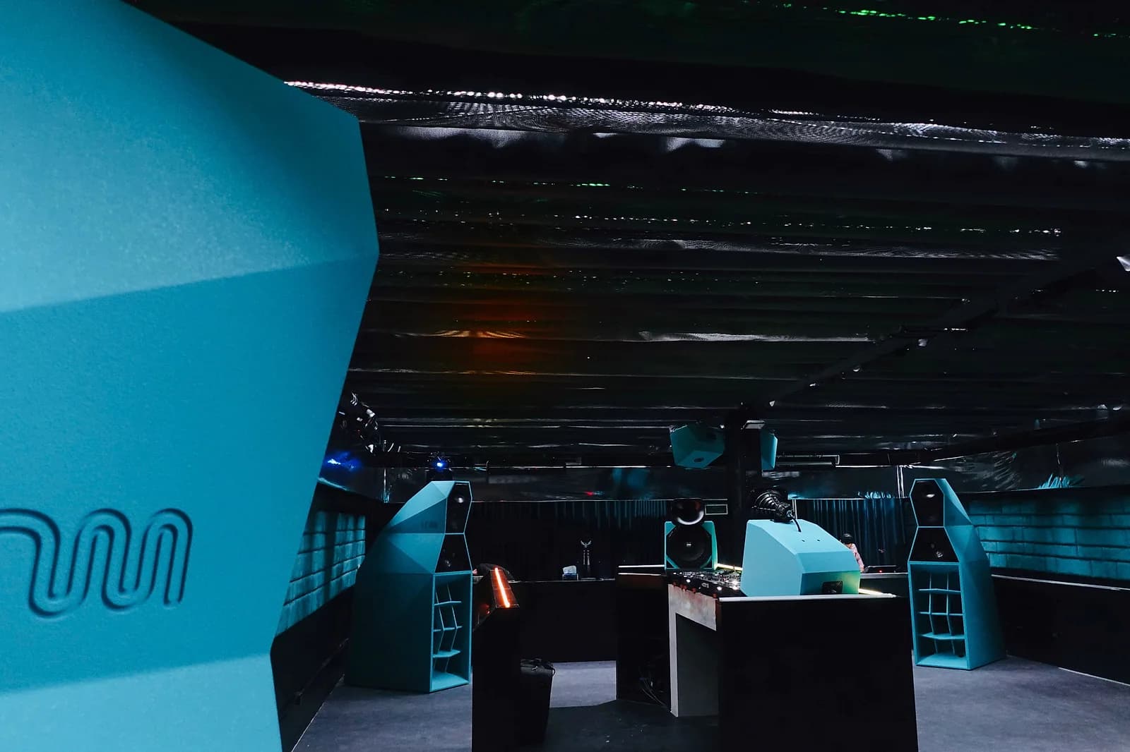Unmute's teal, faceted speaker stacks and spring-loaded room inside Cuốn Club.