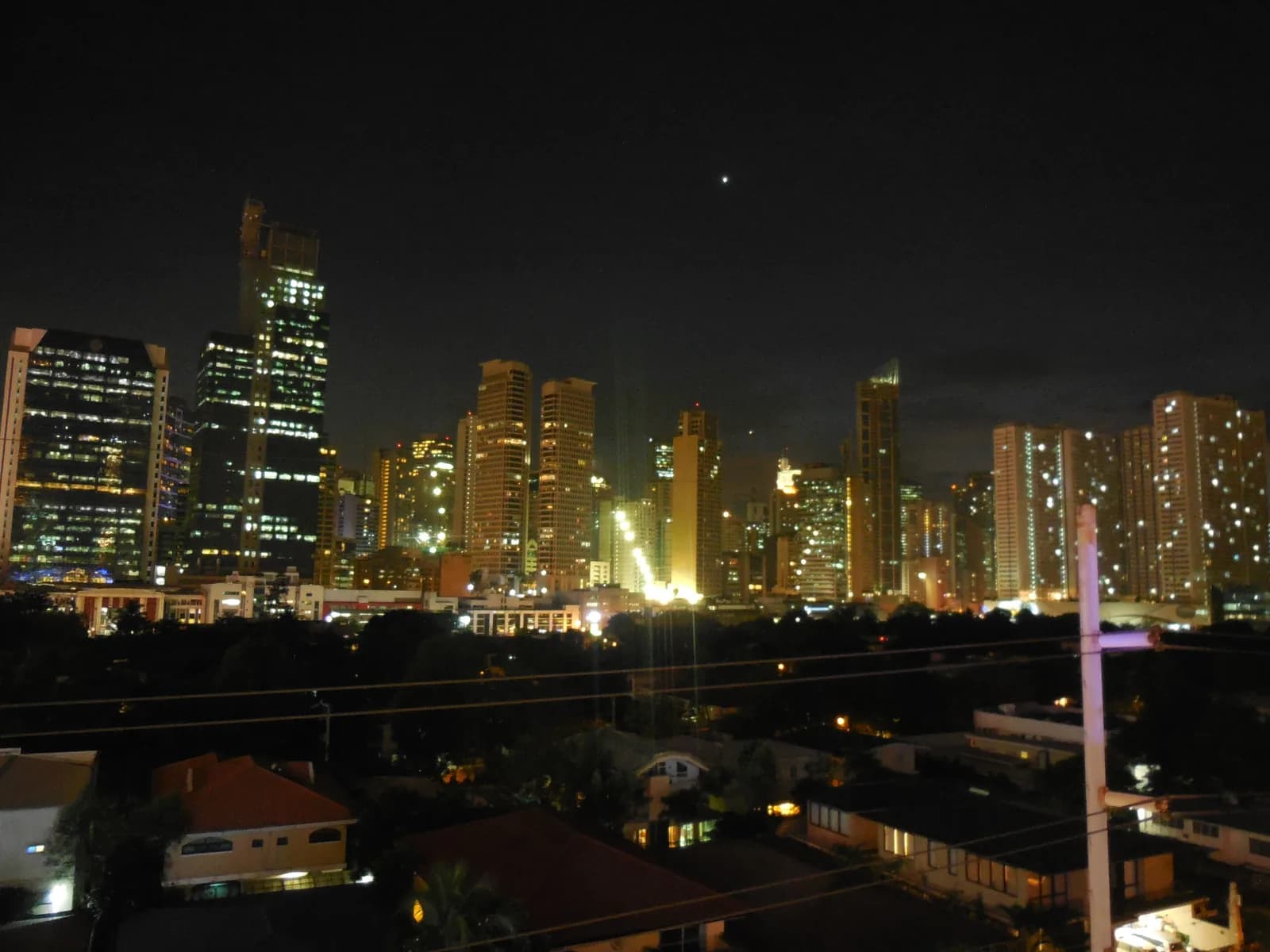 Makati's skyline after dark. Poblacion's club strip sits a few blocks south of these towers, at street level, mostly behind unmarked doors.