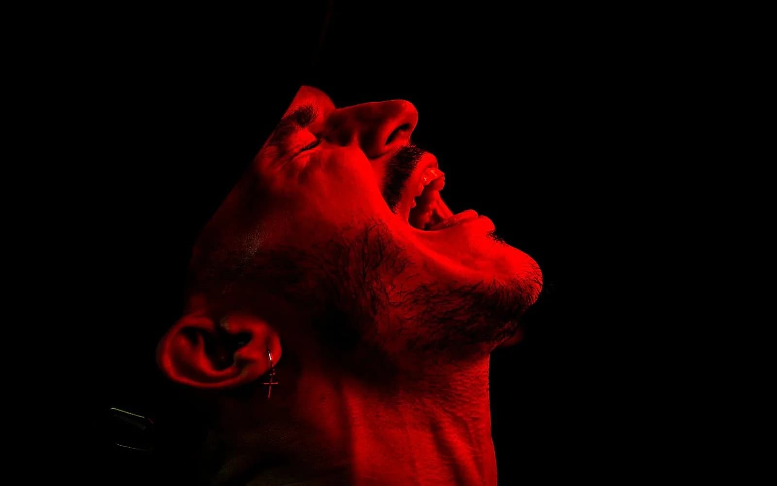 Nico Moreno performing under his signature red stage lighting.