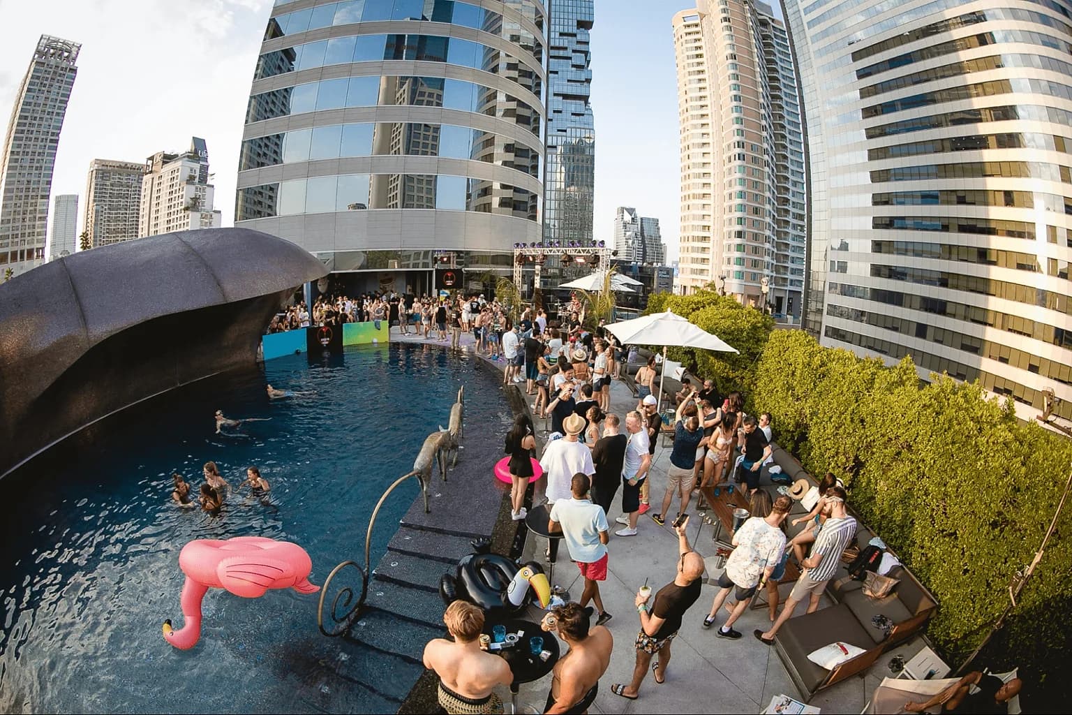 A Bangkok hotel rooftop pool party in full swing on a Saturday afternoon.